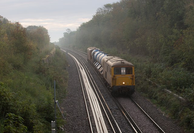 Network Rail signs new deal to keep tracks clear in autumn and winter: A rail head treatment train in the mist outside Whitstable